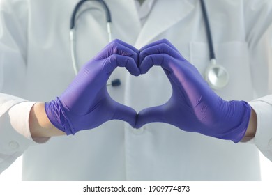 Doctor In Blue Gloves With A Stethoscope Depicts A Heart With His Hands