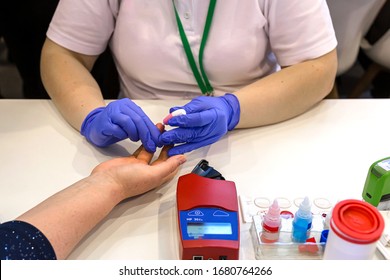 A Doctor In Blue Gloves Takes A Blood Test From A Patient 's Finger. The Test For The Coronavirus. Covid 19.