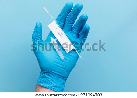 Doctor in blue gloves using a lateral flow covid-19 testing kit