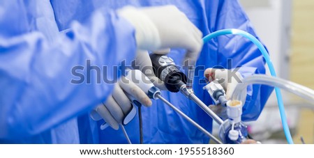 Doctor in blue sterile surgical gown doing surgery with camera and instrument. Keyhole surgery was perform in modern operating room.Advanced laparoscopy.Knee and shoulder joint orthopedic arthroscopy.