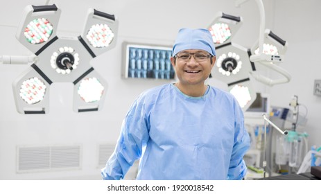 Doctor in blue surgical gown suit working inside modern operating room.Surgeon smiling in Operating room.