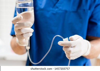 Doctor in blue uniform holding drip iv and infusion pump, . Intravenous fluid for seriously patient in the emergency room at hospital. Medical treatment emergency concept.