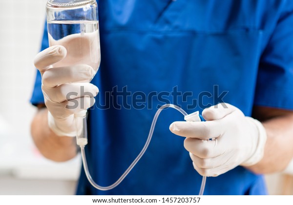 Doctor in blue\
uniform holding drip iv and infusion pump, . Intravenous fluid for\
seriously patient in the emergency room at hospital. Medical\
treatment emergency\
concept.