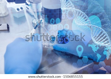 Doctor in brown latex gloves does control check of the in vitro fertilization process inside Petri Dishes with a help of the microscope in the IVF lab. Closeup. Horizontal.