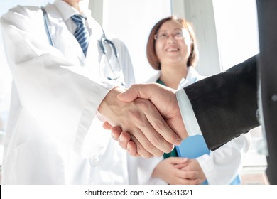 Doctor And Business People Shaking Hands