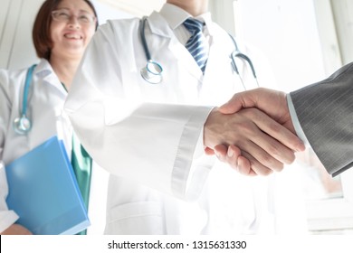 Doctor And Business People Shaking Hands