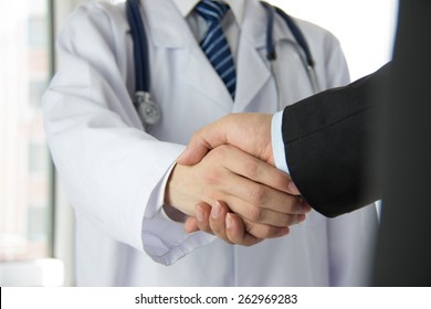 Doctor And Businessman Shaking Hands