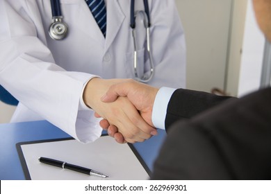 Doctor And Businessman Shaking Hands