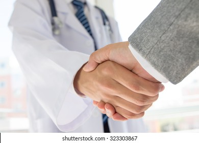 Doctor And Businessman Shaking Hands