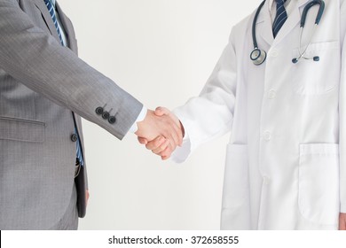 Doctor And Businessman Shaking Hands