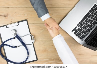 Doctor and businessman shaking hands