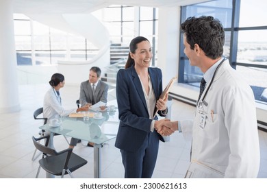 Doctor and businesswoman handshaking in meeting