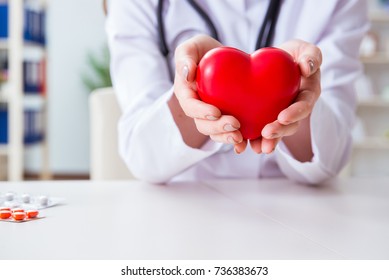 Doctor cardiologist with red heart in the hospital