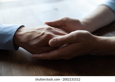 Doctor, Caregiver, Nurse Giving Comfort And Support To Elderly Older Patient. Grown Son Holding Hand Of Senior Older Father Going Through Mental Disorder, Cancer, Loss, Grief. Family Concept. Close Up