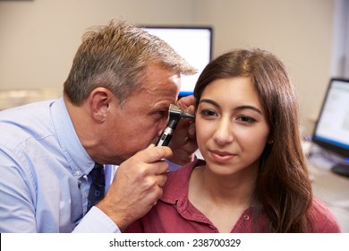 Doctor Carrying Out Ear Exam On Female Patient