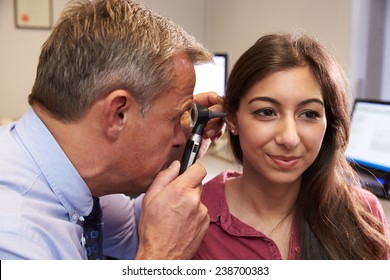 Doctor Carrying Out Ear Exam On Female Patient