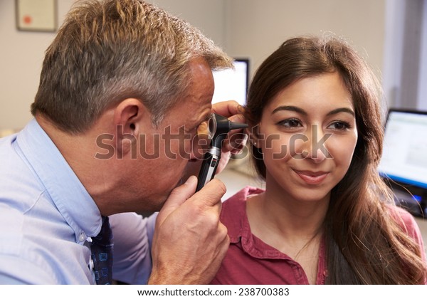 Doctor Carrying\
Out Ear Exam On Female\
Patient