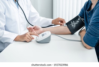 Der Arzt kontrolliert den Blutdruck und verwendet auch ein Stethoskop, um die Krankheitsursache des Patienten zu überprüfen und um die Gesundheitsversorgung im Krankenhausbüro zu beraten