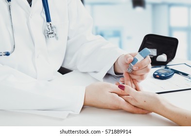 Doctor checking blood sugar level. doctor patient diabetes lancet glucometer blood glucose office concept