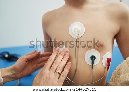 Doctor checking child heart rhythm with ECG holter monitor