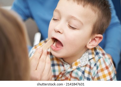 Doctor Checking Child Throat With Tongue Depressor