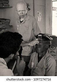 A Doctor Checking The Eyes Of A Teenager And An Albino Guy During Retinoscopy In A Third World Hospital. Yaunde, Cameroon, Africa. May 5, 2018