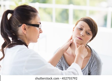 Doctor checking female patient at clinic