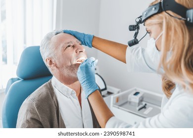 Doctor checking man throat with medical stick. Vocal cords medical health checkup in clinic. Glands swollen. Otorhinolaryngologist visit