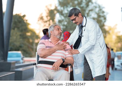 Doctor checking to old man while he is moaning in pain.