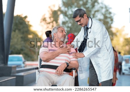 Doctor checking to old man while he is moaning in pain.