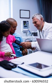 Doctor Checking Patient Blood Pressure In Clinic