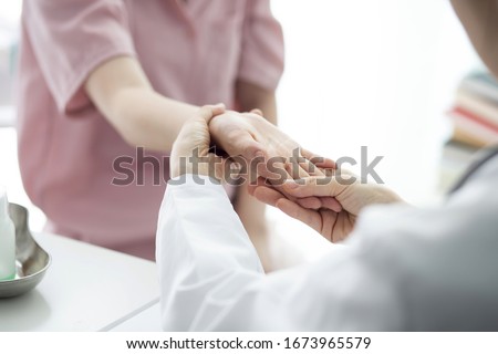 Doctor checking patient's hand pain
