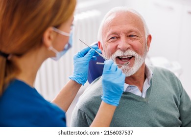 Doctor Checking Up Patient's Teeth At Dentist Office; Senior Man At Dental Checkup