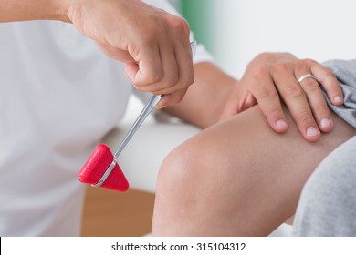 Doctor checking reflexes of the knee of his patient - Powered by Shutterstock