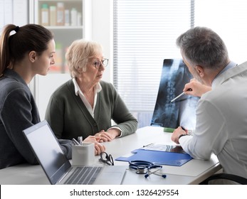 Doctor Checking A Senior Female Patient's X-ray Image During A Visit At The Hospital, Injury And Osteoporosis Concept