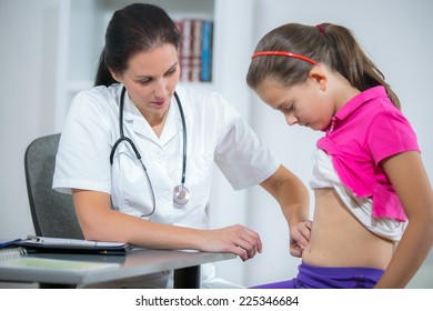 Doctor Checking Stomach Of Sick Girl 