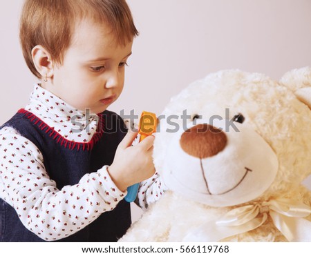Doctor checking teddy bear patient's ear with otoscope (humorous photo)