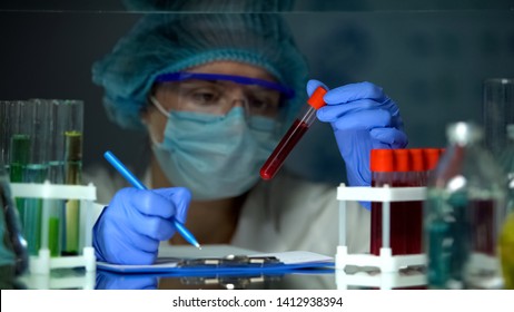 Doctor Checking Tube With Blood Analysis And Making Notes, Lymphoma Cancer