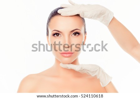 Doctor checking woman's skin before plastic surgery