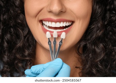 Doctor checking young woman's teeth color, closeup. Dental veneers - Powered by Shutterstock