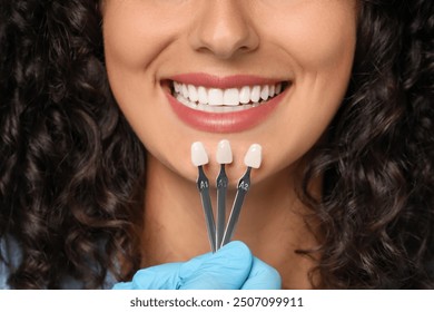 Doctor checking young woman's teeth color, closeup. Dental veneers - Powered by Shutterstock