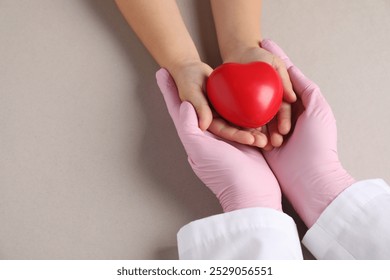 Doctor and child holding heart model on light grey background, above view. Space for text - Powered by Shutterstock