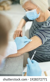 Doctor Cleaning Old Woman Skin With Alcohol Swab Before Injection