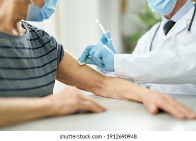 Doctor Cleaning Patient Arm With Alcohol Swab Before Injection