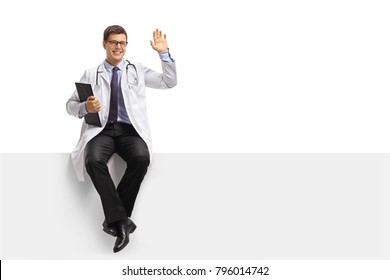 Doctor With A Clipboard Sitting On A Panel And Waving At The Camera Isolated On White Background