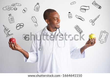 Doctor comparing apples with hand drawn medical sketches. Healthy nutrition concept. Isolated front closeup view with medicine icons on background.
