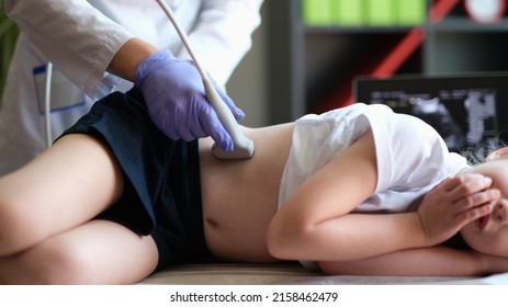 Doctor conducting ultrasound examination of kidneys to child in clinic. Diagnosis of pyelonephritis in children concept - Shutterstock ID 2158462479
