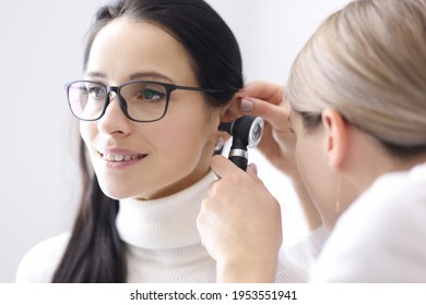 Doctor conducts examinations of ear area for woman - Powered by Shutterstock