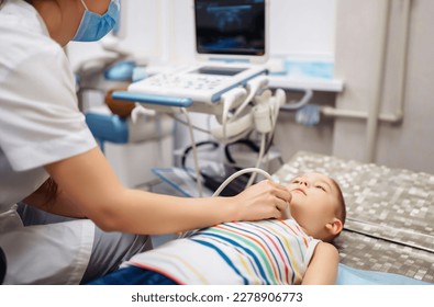 Doctor conducts an ultrasound examination of the heart and abdominal organs of a little boy using modern medical equipment in a clinic. Pediatrics and child development monitoring. - Powered by Shutterstock