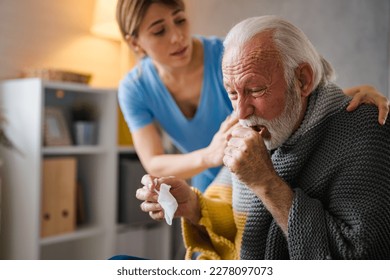 Doctor consoling senior patient at home. Old people senior man with winter seasonal illness fever cold problems. Concept of mature retired with disease. Front view of senior man coughing  - Powered by Shutterstock